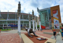 Baseball stadium entrance with a bronze statue outside.