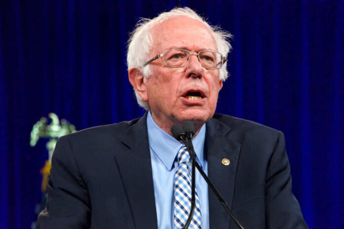 1486814015 Man speaking at podium with blue curtain background.