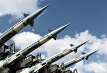 Array of military missiles against a blue sky with clouds