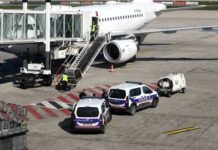 Police vehicles near an airplane at an airport