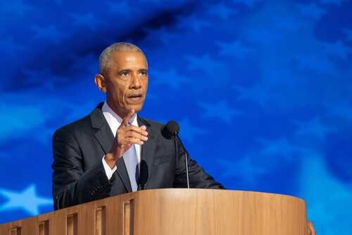 shutterstock_2507620031.jpg A man in a suit delivering a speech at a podium