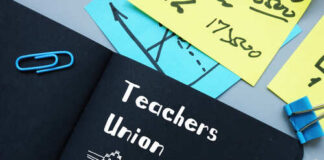 A black notebook with 'Teachers Union' written on it, surrounded by colorful sticky notes and paper clips