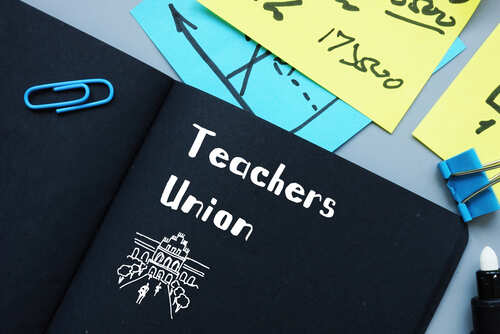 shutterstock_1746940400.jpg A black notebook with 'Teachers Union' written on it, surrounded by colorful sticky notes and paper clips