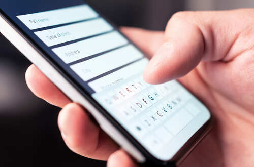 Close-up of a hand using a smartphone to enter information