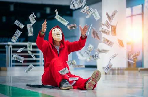 A person in a red jumpsuit and mask surrounded by falling money