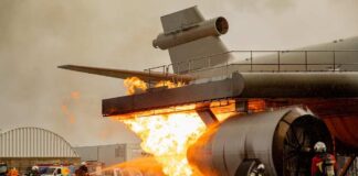 Firefighters battling flames from an aircraft during a training exercise