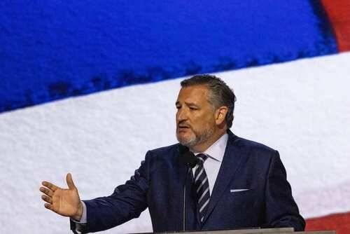 shutterstock_2524663023.jpg Man in a suit delivering a speech at a podium with an American flag backdrop