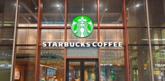 Exterior view of a Starbucks coffee shop with customers seated outside