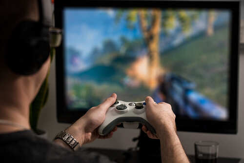 Person playing a video game with a controller in front of a TV