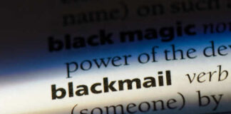 Close-up of a dictionary page showing the definition of 'blackmail'