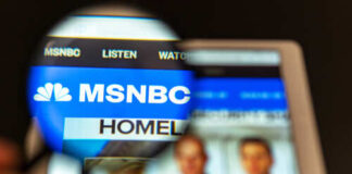 Close-up view of the MSNBC website on a tablet screen through a magnifying glass