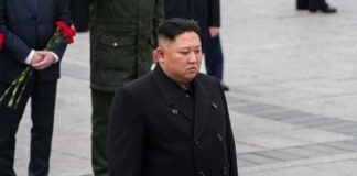 A political figure in formal attire participating in a solemn ceremony