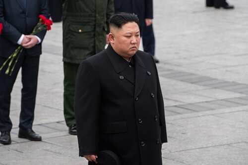 A political figure in formal attire participating in a solemn ceremony