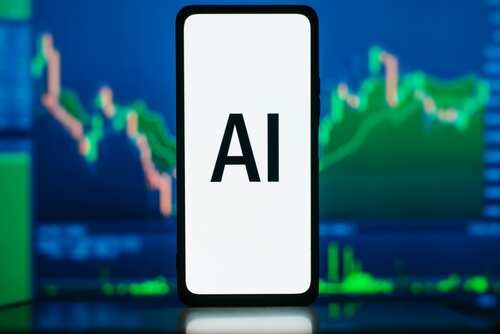 shutterstock_2263337103.jpg Smartphone displaying the text 'AI' in front of financial graphs