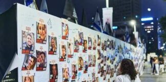 A woman observing a memorial wall filled with photographs and messages