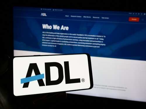 shutterstock_2384981533.jpg Mobile phone displaying the ADL logo in front of a website