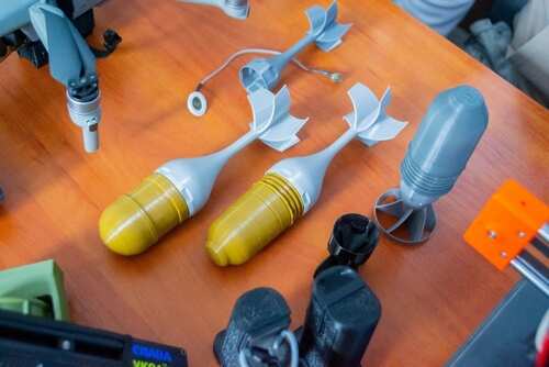 shutterstock_2425477535.jpg Various drone components and model rocket parts displayed on a wooden surface