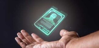 A hand holding a holographic ID card displaying a person's image