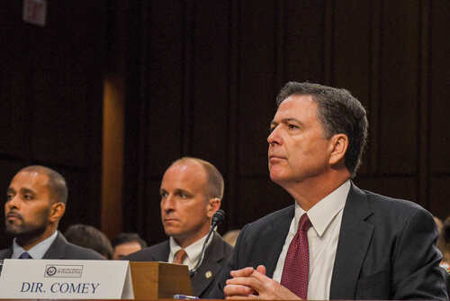 shutterstock_675303589.jpg A man in a suit sitting at a table during a congressional hearing