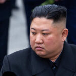 A political figure in formal attire with a contemplative expression