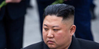 A political figure in formal attire with a contemplative expression