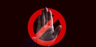 A hand raised in a stop gesture over a prohibition symbol