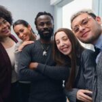 New Policy Sparks Outrage: Police Replaced by Social Workers? A diverse group of five people smiling together in an office setting