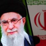 Close-up portrait of a political figure displayed on a smartphone with an Iranian flag background