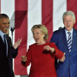 Three public figures smiling and engaging at a political event