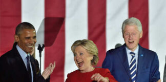 Three public figures smiling and engaging at a political event