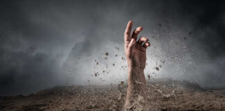 A hand emerging from the ground in a dramatic landscape