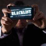 Blacklist Claim Shakes Harris Campaign Person holding a smartphone displaying the word 'BLACKLIST'