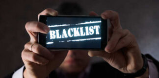 Person holding a smartphone displaying the word 'BLACKLIST'