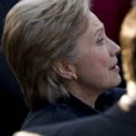 Epstein Deposition ERUPTS After Photo Leak Person with short blonde hair, wearing gold earrings.