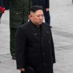 A political figure in formal attire participating in a solemn ceremony