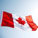 Alabama Beats Canada—How Is That Possible? Waving Canadian flag against a clear sky