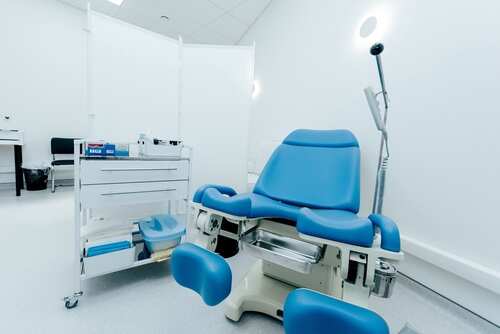 A blue medical examination chair in a sterile healthcare room