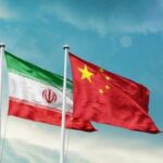 China Arms Iran Against Trump Flags of Iran and China waving against a blue sky