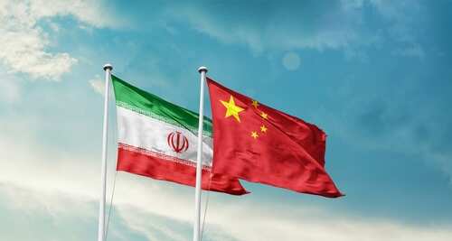 Flags of Iran and China waving against a blue sky