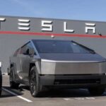Tesla Slashes Cybertruck Prices—Demand Trouble? Tesla Cybertruck parked in front of a Tesla building