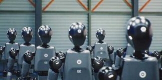Row of humanoid robots standing in a warehouse