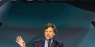 Man speaking at podium with microphone and gesturing