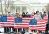 Group of young protesters holding American flags in front of the White House