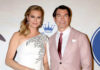 A couple posing together at a formal event on the red carpet