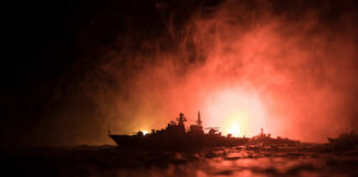 Silhouetted model ships against a smoky, illuminated background