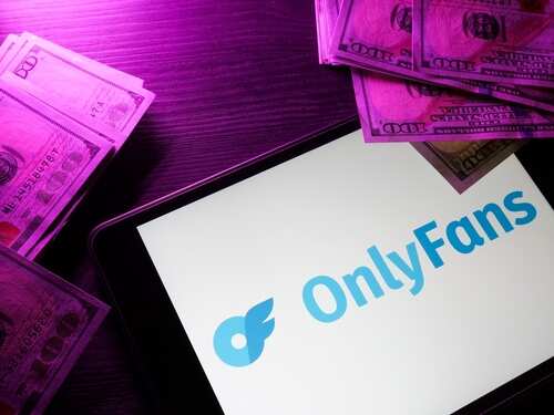 OnlyFans logo displayed on a tablet surrounded by cash