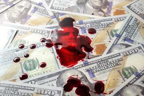 shutterstock_2178326183.jpg A pool of blood on a background of hundred dollar bills