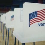 Voter Revolt Is Brewing! Voting booths with American flags in a polling place