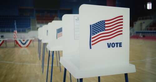 Voting booths with American flags in a polling place