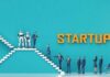 Business professionals and robots on stairs with 'STARTUP' text